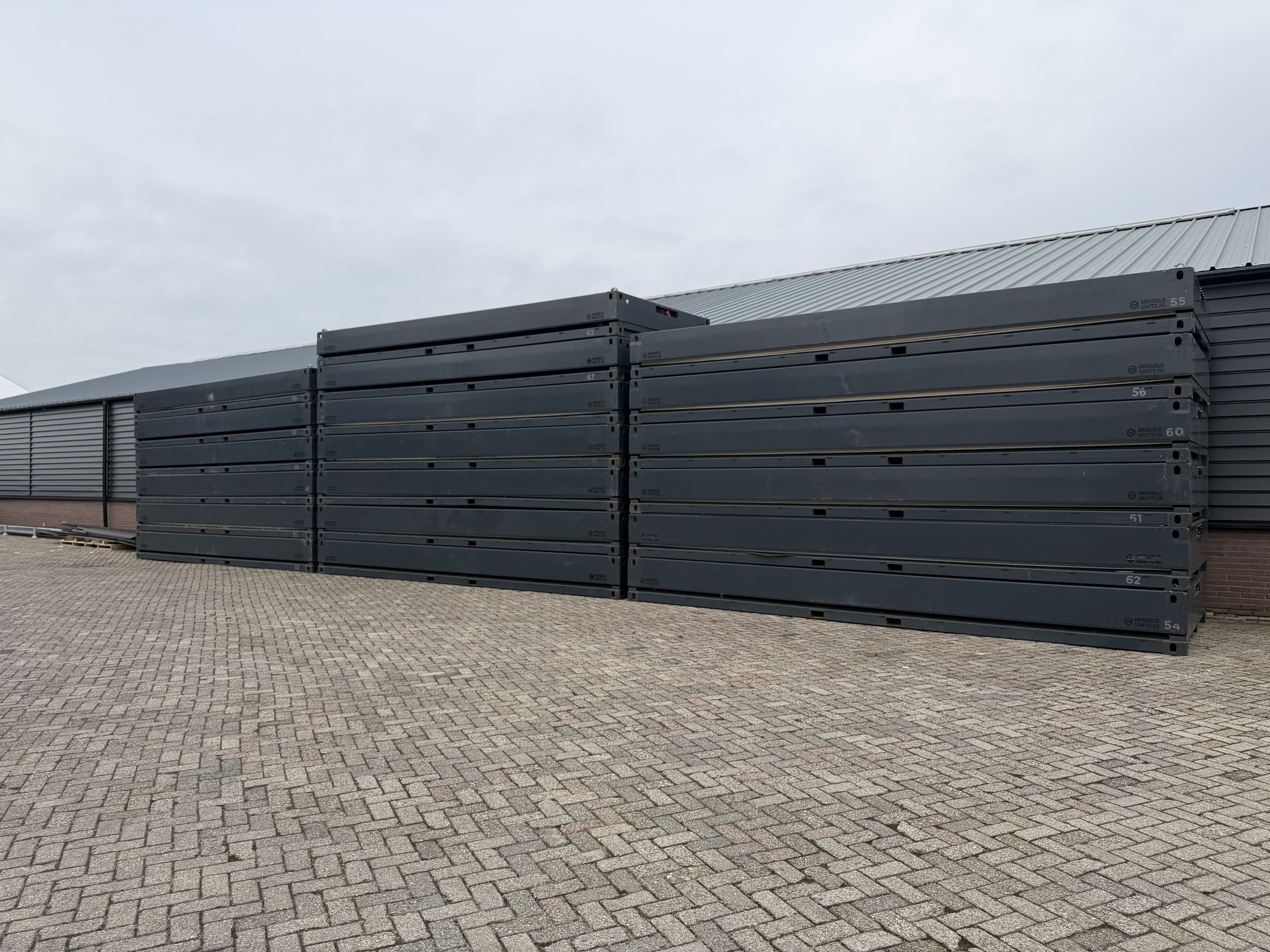 Drie opvouwbare units in gesloten toestand op een parkeerterrein